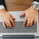 A person types on a laptop at a desk