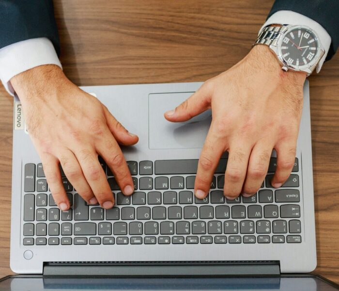 A person types on a laptop at a desk