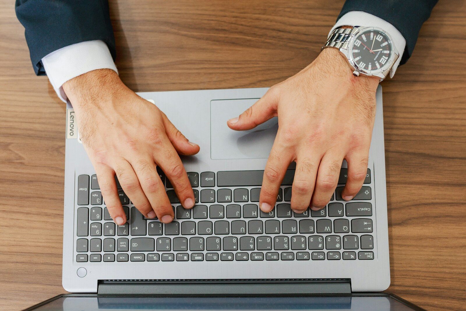 A person types on a laptop at a desk